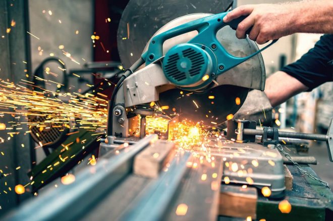 industrial worker using a compound mitre saw industrial worker using a compound mitre saw with circular blade for cutting metal and plastic